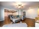 Open-concept living room featuring a leather sofa, hardwood floors, and an open dining room for modern living at 5230 Harris Springs Dr, Cumming, GA 30040