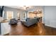 Spacious living room boasting hardwood floors with a large gray sofa set and views into the dining area at 5230 Harris Springs Dr, Cumming, GA 30040