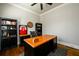 Well-appointed office with a large wooden desk, built in bookshelves, and a black leather chair at 5230 Harris Springs Dr, Cumming, GA 30040