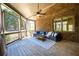 Relax on the screened-in porch with a brick exterior and a cozy seating area with a ceiling fan at 5230 Harris Springs Dr, Cumming, GA 30040
