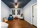 Basement sitting room with hardwood floors, chairs, built-in shelving, and a dark blue ceiling with fan at 5230 Harris Springs Dr, Cumming, GA 30040