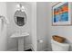 Cozy powder room featuring a pedestal sink, toilet, decorative mirror, and stylish artwork at 2740 Bell Se Dr, Smyrna, GA 30080