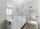 Bathroom vanity featuring double sinks, white cabinets, and a large mirror at 840 Franklin Mill Trce, Loganville, GA 30052