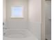 Bathroom features a soaking tub with subway tile surround and window at 1088 Blue Juniper Cir, Loganville, GA 30052