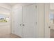 Hallway with double doors, neutral carpet, and natural light from a window at 1088 Blue Juniper Cir, Loganville, GA 30052