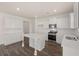 Bright kitchen features white cabinets, countertops, island and stainless steel appliances with hardwood floors at 1088 Blue Juniper Cir, Loganville, GA 30052