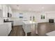 New kitchen boasts stainless appliances, white cabinets, backsplash and island with hardwood floors and open to the living room at 1088 Blue Juniper Cir, Loganville, GA 30052