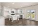 Bright kitchen featuring white cabinets, a center island, stainless steel appliances, and wood floors at 1088 Blue Juniper Cir, Loganville, GA 30052