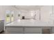 Kitchen features white cabinets and countertops, stainless steel appliances and is open to the living room at 1088 Blue Juniper Cir, Loganville, GA 30052