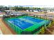 Aerial view of community tennis courts featuring a green and blue surface and new fencing at 1088 Blue Juniper Cir, Loganville, GA 30052