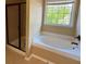 Bright bathroom with separate shower stall and a large soaking tub near a sunlit window at 2530 Gold Creek Ln, Cumming, GA 30041