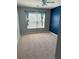Carpeted bedroom with a large window, blue accent wall, and neutral-tone walls at 2530 Gold Creek Ln, Cumming, GA 30041