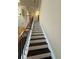A modern black and white stairway featuring a wood banister with ornate wrought iron spindles at 2530 Gold Creek Ln, Cumming, GA 30041