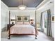 Elegant main bedroom features a trey ceiling, chandelier lighting and a luxurious, comfortable four-poster bed at 4 Candler Grove Dr, Decatur, GA 30030