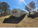 Side view of a charming home with a partially visible basement and a lush, green lawn at 74 Sandy Path, Rockmart, GA 30153