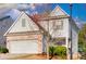 View of a charming two-story home with gray siding and brick accents, showcasing its curb appeal at 1340 Aster Ives Dr, Lawrenceville, GA 30045