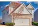Charming home with gray siding and brick accents, complemented by budding trees in a lush landscape at 1340 Aster Ives Dr, Lawrenceville, GA 30045