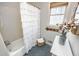 Bathroom featuring a shower with white ruffled curtain, a window, and blue patterned tile flooring at 1376 Highway 138 E, Stockbridge, GA 30281