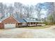Inviting home featuring a brick facade, dormer windows, and mature trees at 1376 Highway 138 E, Stockbridge, GA 30281