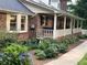 Well-maintained front yard featuring lush landscaping and a quaint covered porch with white railings at 1376 Highway 138 E, Stockbridge, GA 30281