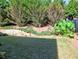 A backyard with a tiered garden and a lush lawn shaded by mature trees at 801 Rutledge Ct, Woodstock, GA 30188