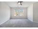 Empty bedroom offers neutral walls, gray carpeting and a ceiling fan with natural light at 2011 Farm Hill Ct, Stockbridge, GA 30281