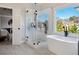 Bright bathroom with soaking tub, glass enclosed shower and a large window with neighborhood views at 6305 Deerwoods Trl, Alpharetta, GA 30005