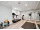 Well-lit exercise room featuring a treadmill, stationary bike, weights, and mirrored wall at 6305 Deerwoods Trl, Alpharetta, GA 30005
