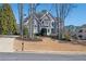 Stately gray two-story home featuring a manicured lawn and mature trees at 6305 Deerwoods Trl, Alpharetta, GA 30005