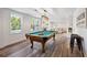 Inviting game room with large window, beautiful flooring, classic billiard table, and counter seating at 6305 Deerwoods Trl, Alpharetta, GA 30005