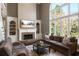 Inviting living room features a stone fireplace, built-in shelves, and an oversized window offering backyard views at 6305 Deerwoods Trl, Alpharetta, GA 30005