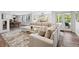 Spacious living room with large sectional sofa, area rug, and game room in the background at 6305 Deerwoods Trl, Alpharetta, GA 30005