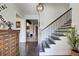 Bright foyer featuring hardwood floors, a staircase with iron railing, and a decorative light fixture at 164 Inwood Walk, Woodstock, GA 30188