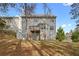Exterior back view of the home with deck and mature trees on a sunny day at 2557 Tolliver Dr, Ellenwood, GA 30294
