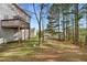 View of the backyard and lower-level deck with mature trees in the background at 2557 Tolliver Dr, Ellenwood, GA 30294