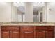 Bathroom featuring a double vanity with granite countertops, mirrors, and wooden cabinetry at 2557 Tolliver Dr, Ellenwood, GA 30294