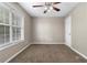 Bedroom featuring a window view, neutral walls, plush carpeting, and a modern ceiling fan at 2557 Tolliver Dr, Ellenwood, GA 30294