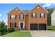 Two story brick home with a well-manicured lawn, a two car garage and black shutters at 2557 Tolliver Dr, Ellenwood, GA 30294