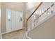 Bright foyer showcases a staircase with wood banister and white trim, complemented by tile flooring at 2557 Tolliver Dr, Ellenwood, GA 30294