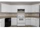 Well-lit kitchen featuring white cabinets, modern appliances, and granite countertops at 2557 Tolliver Dr, Ellenwood, GA 30294