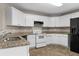Updated kitchen with white cabinets, granite countertops, and stainless steel appliances at 2557 Tolliver Dr, Ellenwood, GA 30294