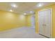 Finished basement space with neutral carpet and a bright yellow wall, and recessed lighting at 5594 Mountain View Pass, Stone Mountain, GA 30087