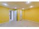 Bright finished basement with yellow walls, off-white carpet and white doors at 5594 Mountain View Pass, Stone Mountain, GA 30087