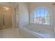 Bright bathroom with a soaking tub, a shower stall and an arched window with views at 5594 Mountain View Pass, Stone Mountain, GA 30087