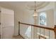 Upstairs hallway features a decorative light fixture and trim, with a window looking over the front lawn at 5594 Mountain View Pass, Stone Mountain, GA 30087