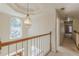 Upstairs hallway features a decorative light fixture and trim, with a window looking over the front lawn at 5594 Mountain View Pass, Stone Mountain, GA 30087