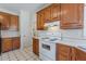 Kitchen features wood cabinets, white appliances, and tiled floors at 5594 Mountain View Pass, Stone Mountain, GA 30087