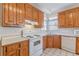 Kitchen with wood cabinets, white appliances, and bright natural light at 5594 Mountain View Pass, Stone Mountain, GA 30087