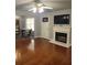 Bright living room featuring hardwood floors, a fireplace, and a ceiling fan at 10221 Deep Creek Pl, Union City, GA 30291