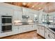 Modern kitchen features white cabinets, wooden ceiling, stainless steel appliances, and hardwood floors at 2987 Jefferson St, Atlanta, GA 30341